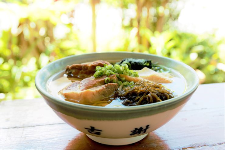 すっきりしたスープに白い麺の宮古そば。豚バラ肉とさつま揚げがトッピングされているのが特徴 提供：古謝そば屋