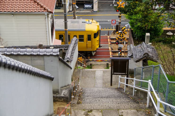 坂の多い尾道市街を走る電車